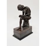 Bronze figure of a seated young nude male , looking at the sole of his left foot, blindstamp foundry