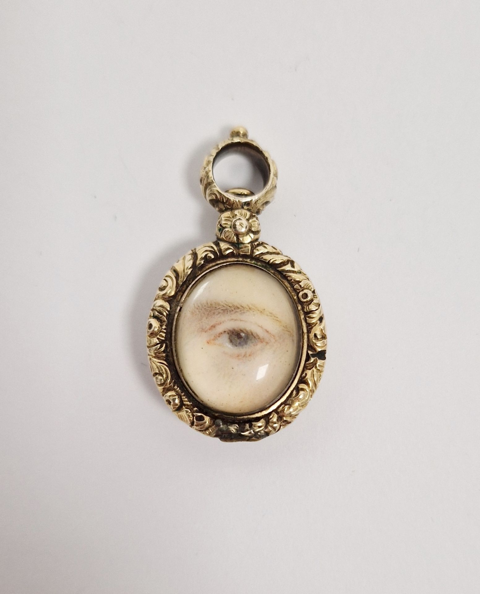 Georgian gold-coloured metal lovers eye painted pendant, oval with eye painting, on ivory, beneath