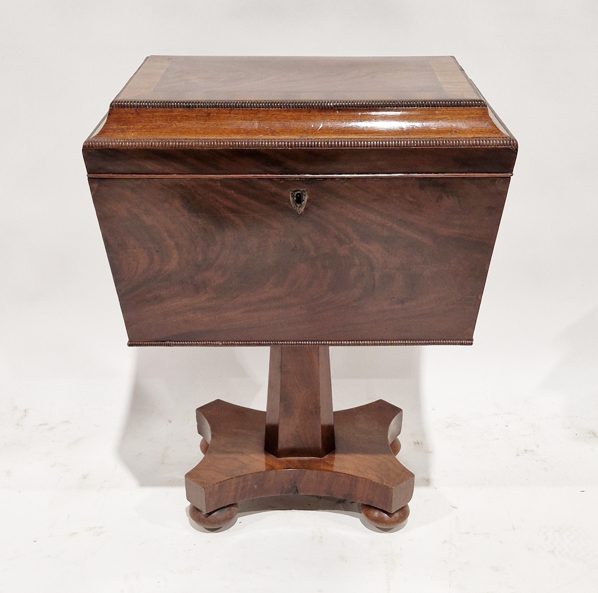 George IV mahogany sarcophagus-shaped cellarette with knulled borders, fitted interior, raised on