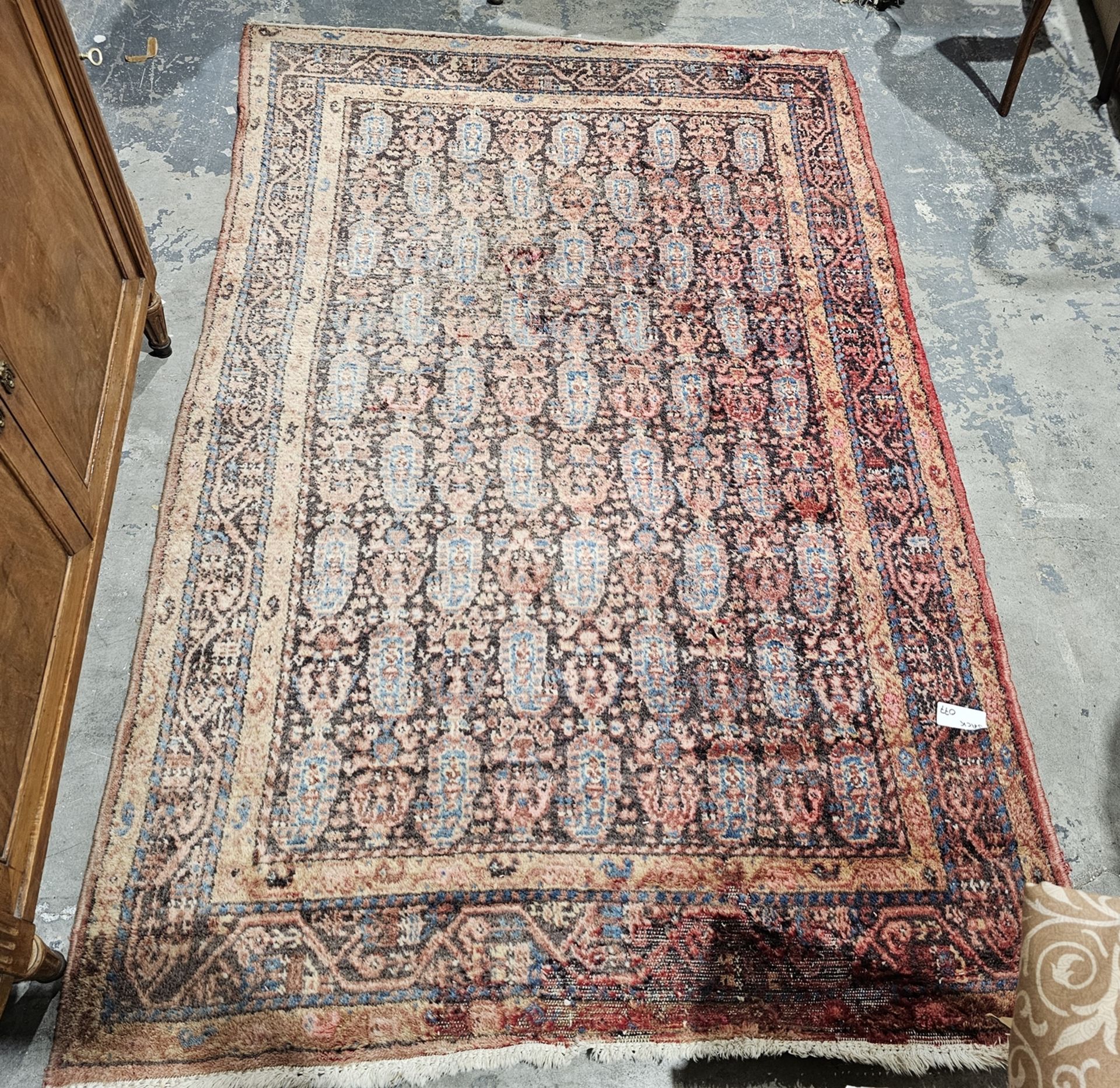 Eastern red ground rug with boteh field, multiple geometric borers (very worn and sun bleached),