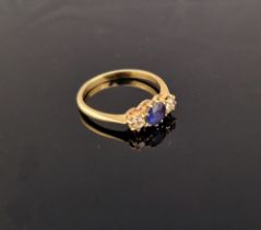 Gold-coloured metal, sapphire and diamond ring, the circular sapphire flanked by two diamonds, all
