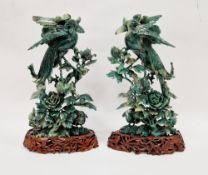 Pair of carved jadeite models of birds of paradise and other birds amidst foliage and flowers,