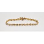 10K gold and diamond bracelet, the small diamonds in illusion setting with foliate X links, 5.5g