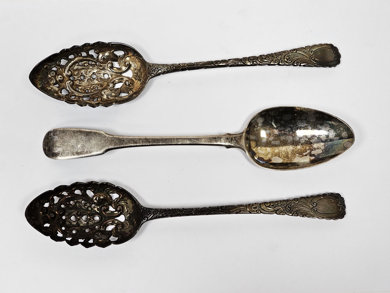 Three George III silver tablespoons, one fiddle pattern, London 1815, the other two London 1803