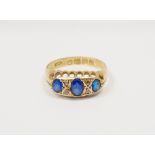 18ct gold and blue stone ring set three oval facet-cut graduated stones alternating with four tiny