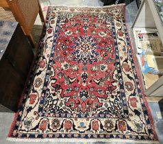 Large red ground rug with central floral medallion on floral field and floral spandrels, multiple