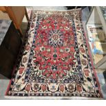 Large red ground rug with central floral medallion on floral field and floral spandrels, multiple