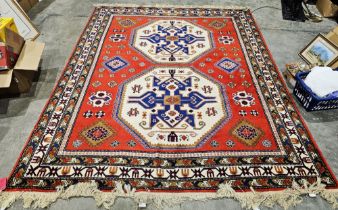 Russian red ground kazak carpet with two large central octagonal hooked medallions on geometric