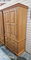 20th century pine two-door wardrobe, opening to reveal a removable clothes rail, over two short