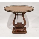 An Empire-style occasional table, of oval form, with pierced brass gallery raised on lyre-shaped