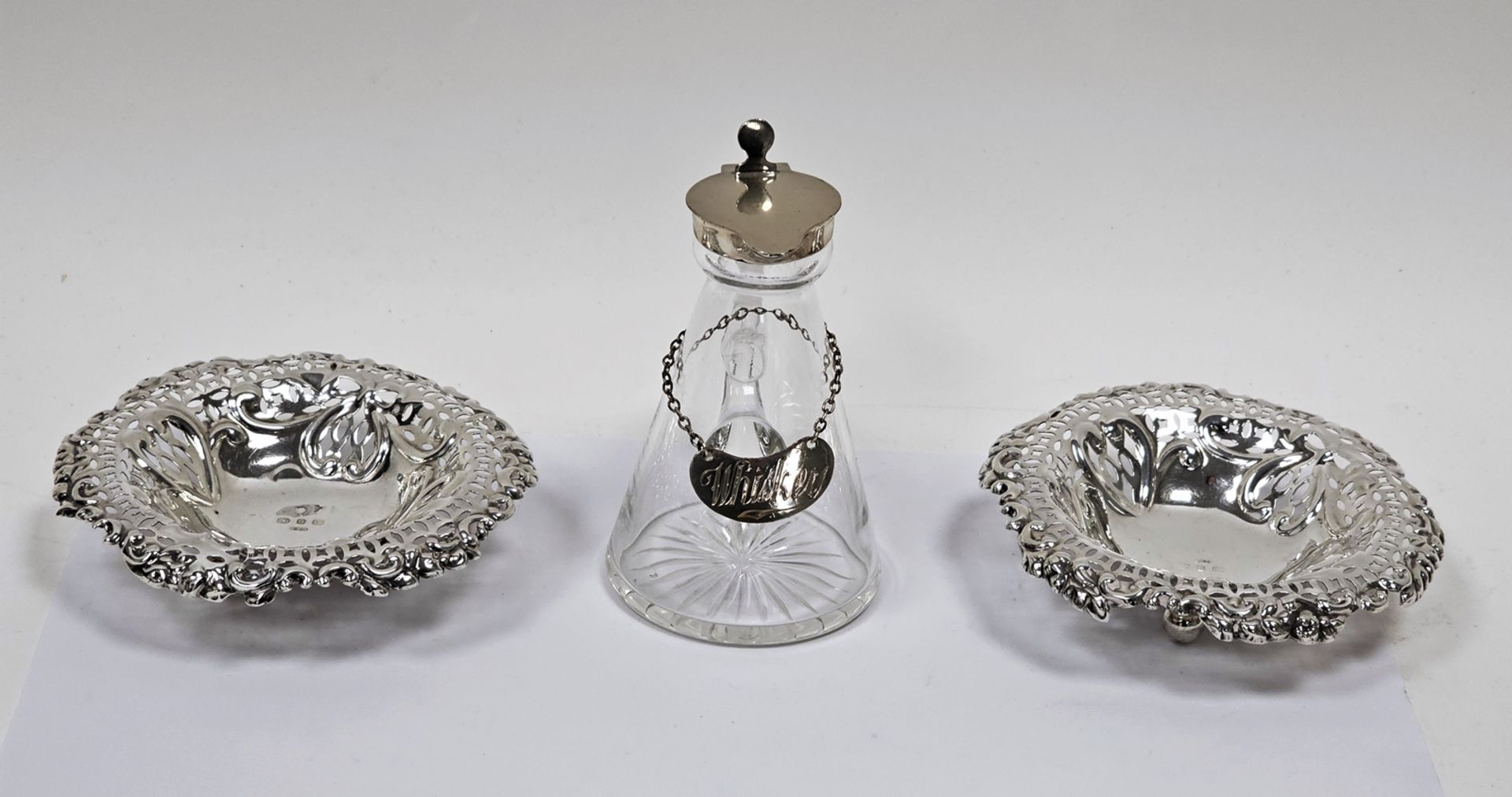 Pair of Victorian silver reticulated pin trays and a silver-mounted glass whisky tot and label,