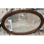 Early 20th century oak framed bevelled edge wall mirror of oval form, 77cm x 50cm
