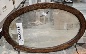 Early 20th century oak framed bevelled edge wall mirror of oval form, 77cm x 50cm