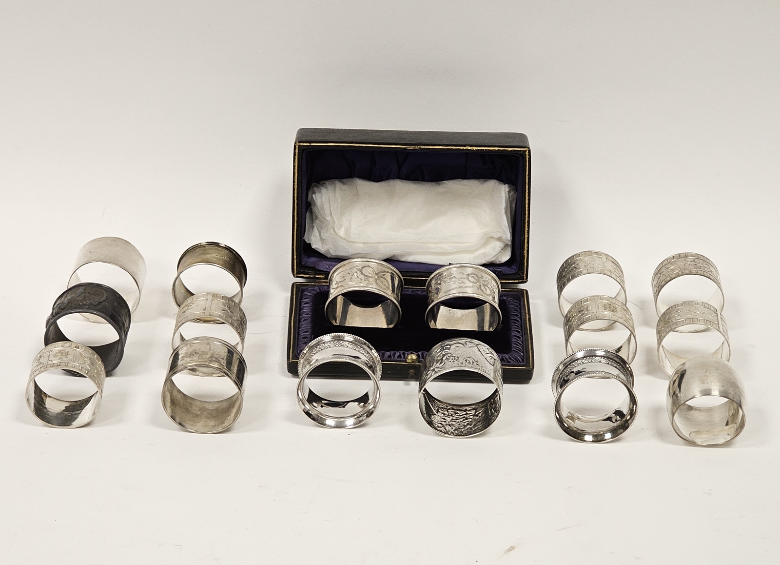 A collection of various silver and white metal napkin rings, including British and continental