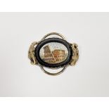 Gilt metal micro-mosaic brooch depicting the Colosseum, with scroll borders