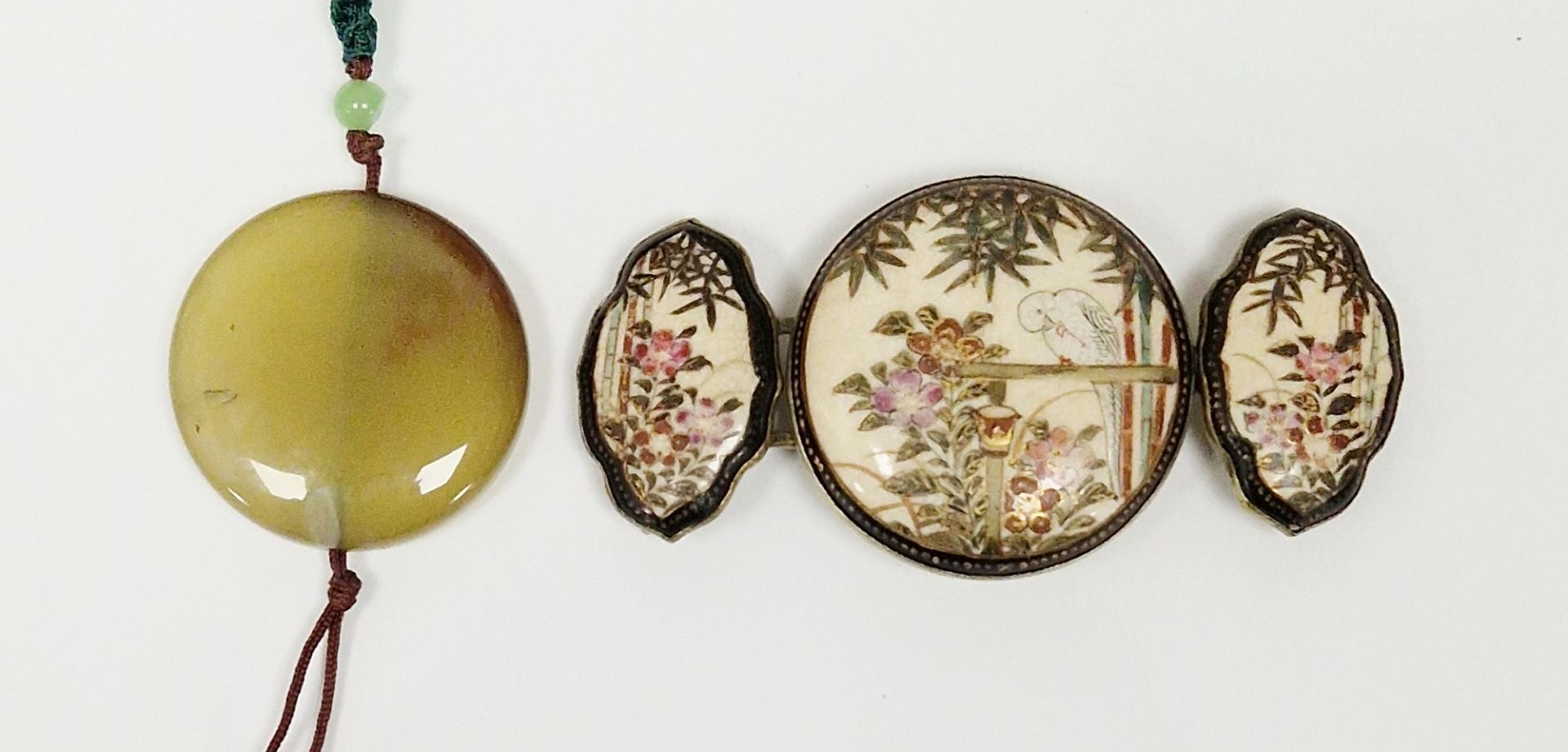 Japanese satsuma earthenware buckle in three sections, circular and shaped oval, painted with