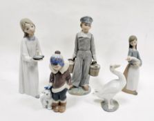 Collection of Lladro figures comprising a girl with candlestick, a boy holding two pails, a boy