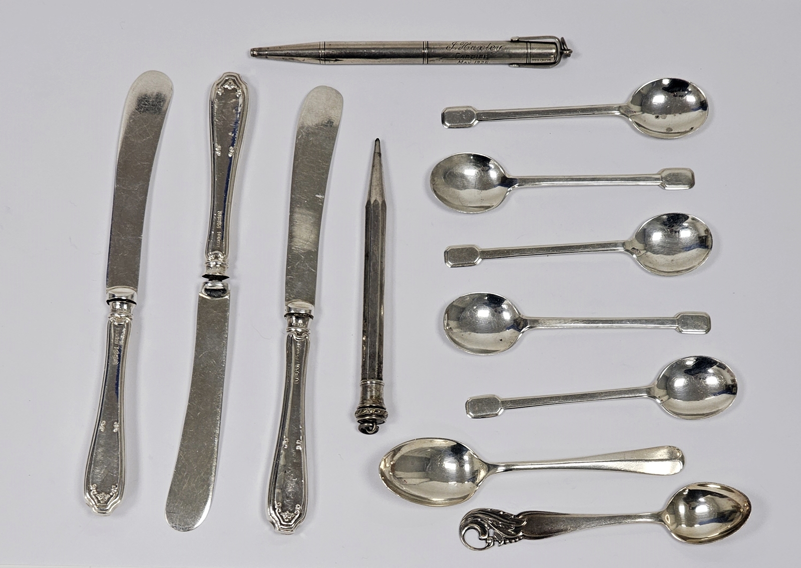 Two various silver-coloured metal propelling pencils, five silver coffee spoons with spade handles