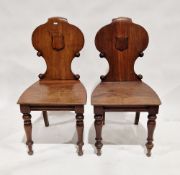 Pair of Victorian mahogany hall chairs with raised shield to seat back, on turned front legs, 89cm