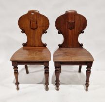Pair of Victorian mahogany hall chairs with raised shield to seat back, on turned front legs, 89cm
