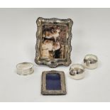 Three various silver napkin rings, silver photograph frame, rectangular with scroll and foliate