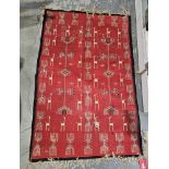 Red ground rug with stylised animal and geometric pattern with single black border, 150cm x 97cm