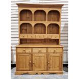 19th century pine kitchen dresser, the top section with two plateracks and five short drawers, the