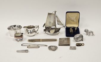 A collection of silver and white metal objects, including an egg shaped thimble case and needle