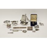 A collection of silver and white metal objects, including an egg shaped thimble case and needle