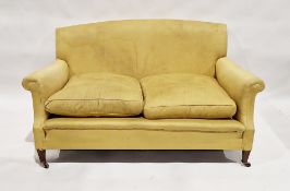 Late 19th/early 20th century Howard & Sons sofa upholstered in a gold fabric, on mahogany legs