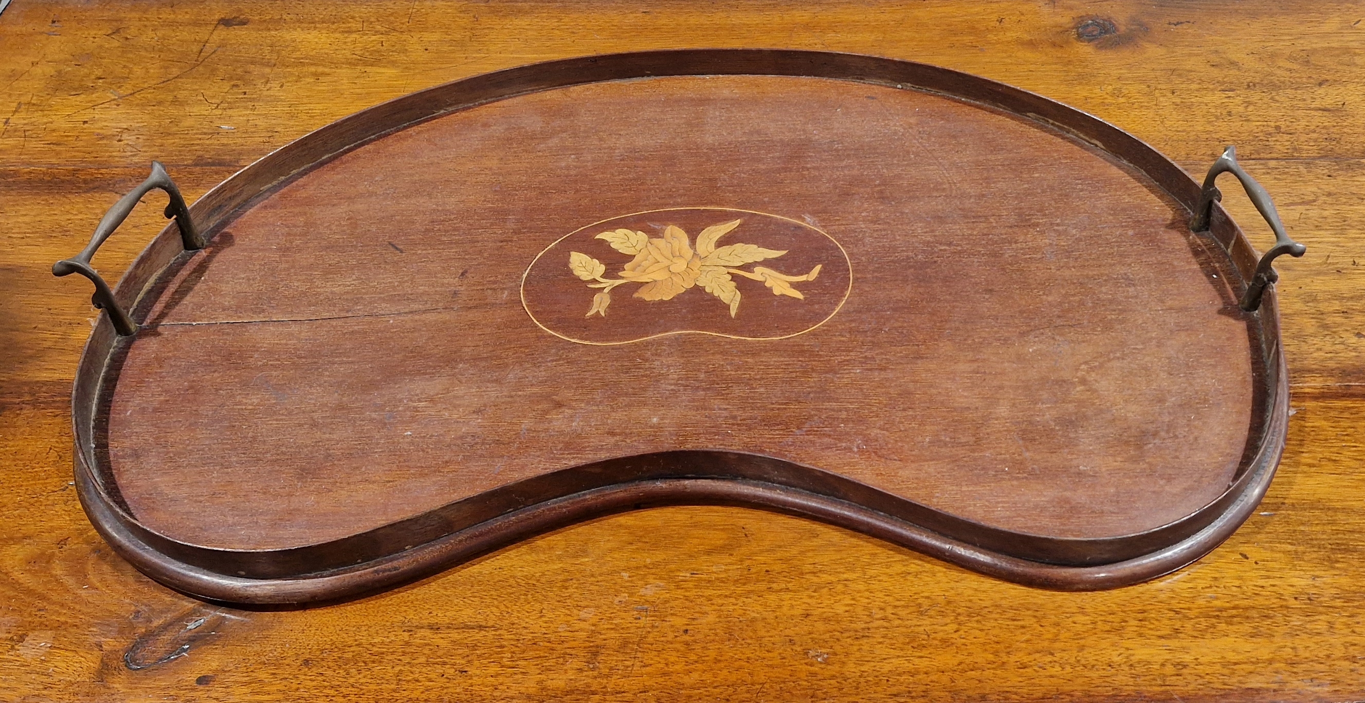 Edwardian mahogany marquetry inlaid two-handled tray, kidney-shaped and with brass end handles, 58cm