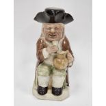 Late 18th century Ralph Wood-type creamware toby jug and cover, modelled seated holding a mug of ale