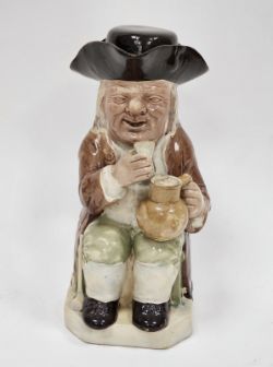 Late 18th century Ralph Wood-type creamware toby jug and cover, modelled seated holding a mug of ale