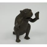 Early 20th century bronze model of a monkey, seated and holding its arms as if in support, jaw