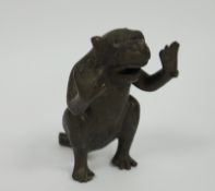 Early 20th century bronze model of a monkey, seated and holding its arms as if in support, jaw