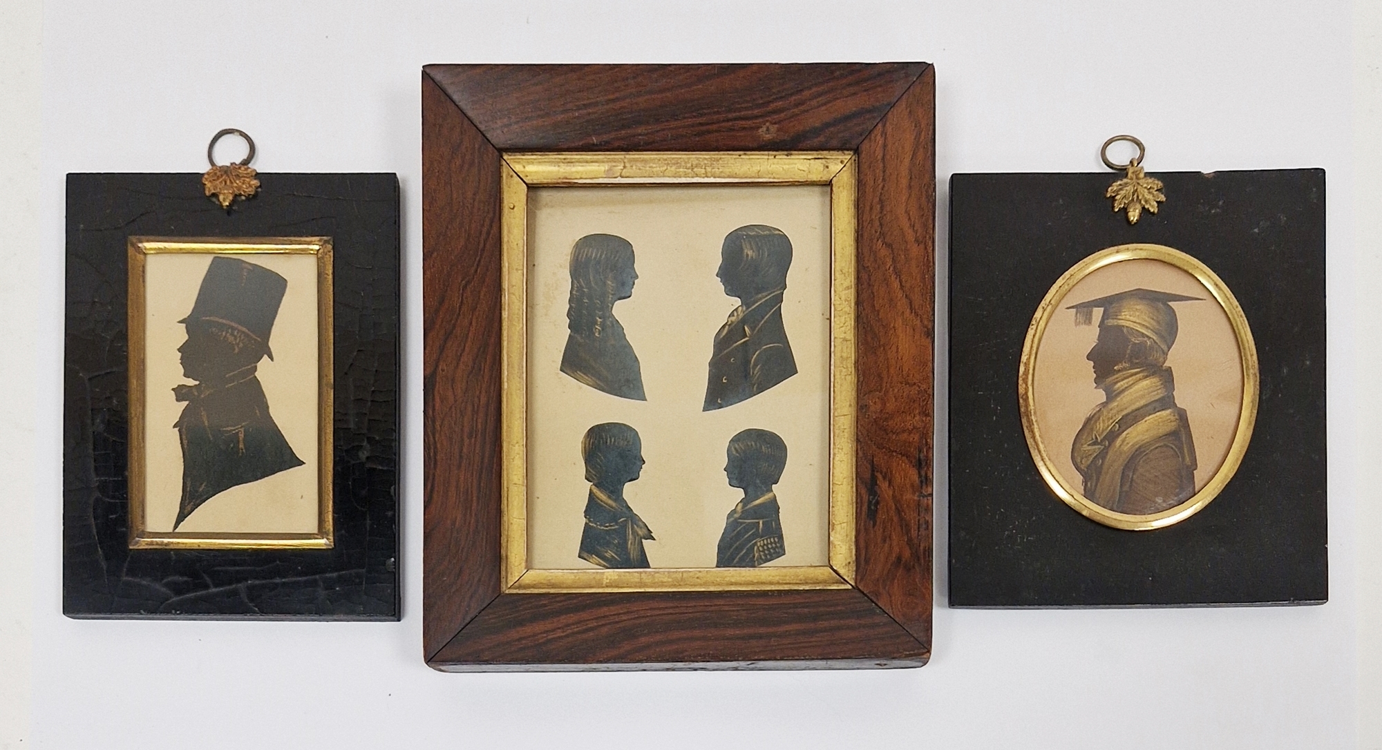 19th century silhouette on card, four busts of children with gilt highlights, framed and glazed,