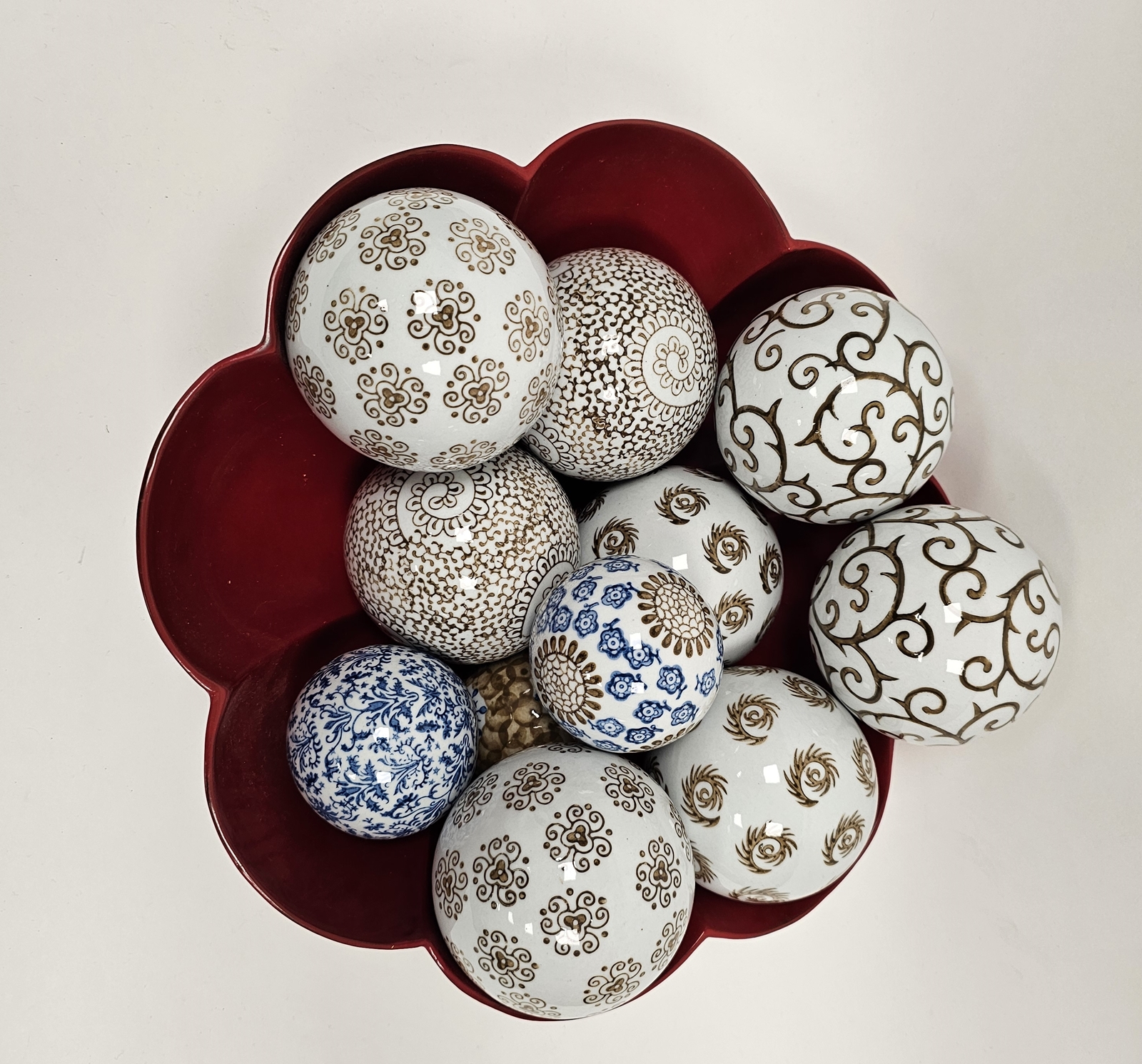 Quantity of printed ceramic spheres with scroll and stylised floral decoration in red lacquered bowl - Image 2 of 2