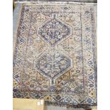 Eastern wool rug of caucasian design with two stepped octagonal blue medallions to the madder field,