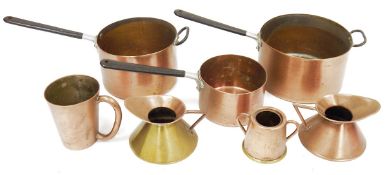 Set of three copper graduated saucepans with black stick  handles and a small quantity of copperware