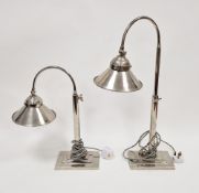 Pair chromium plated adjustable arched top table lamps with conical shades, on stepped rectangular