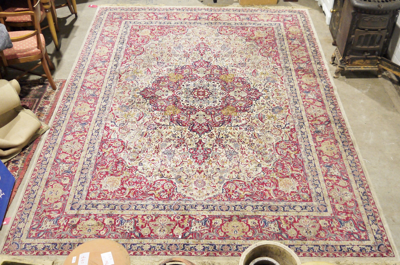 Large Persian-style cotton carpet with red floral arabesque on an ivory ground, red spandrells,
