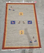 Indian wool grey ground rug with stylised animals and females to the field, single brown border