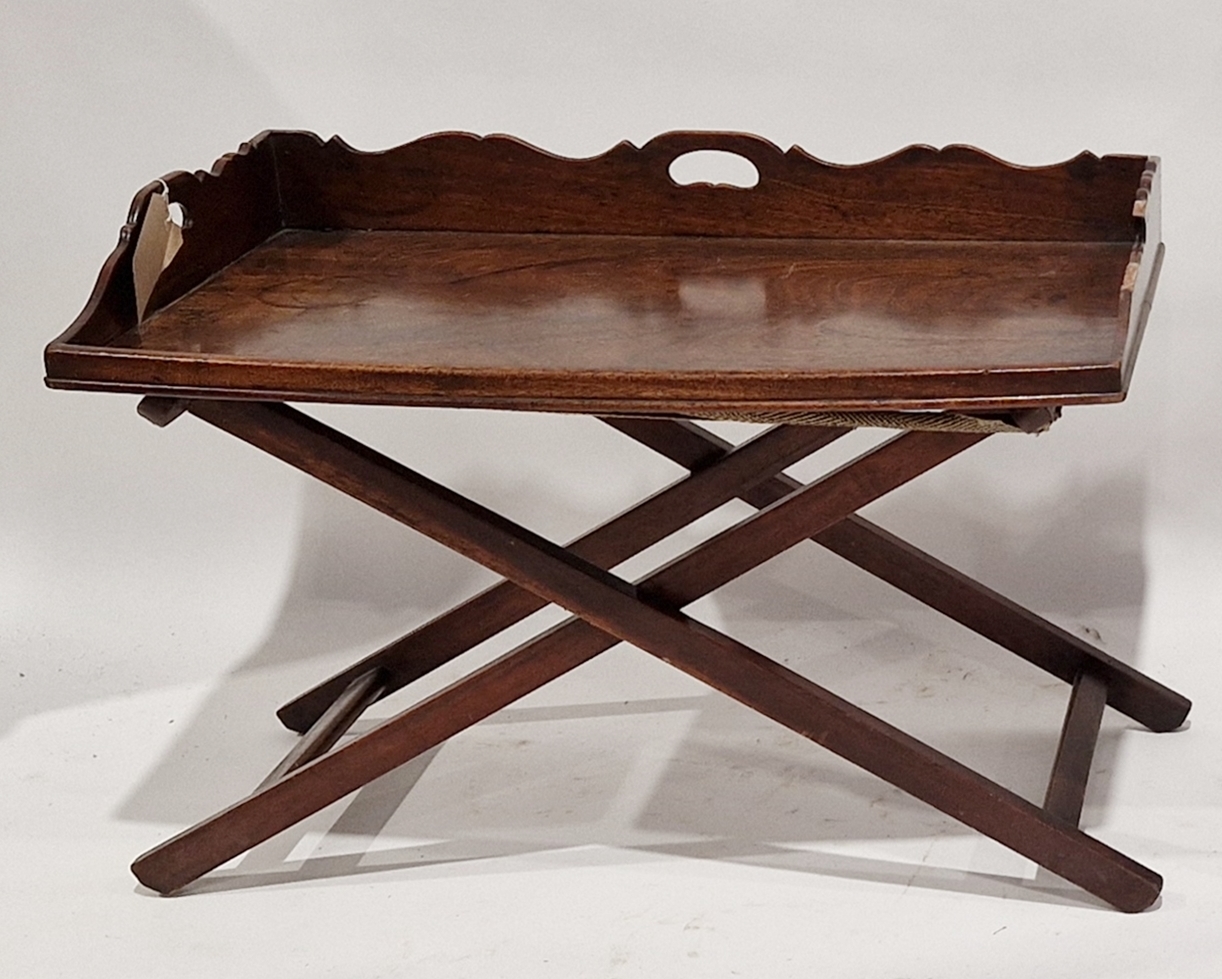 Mahogany butler's tray on folding X-frame stand, the tray with shaped three-quarter gallery and