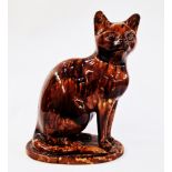 20th century pottery model of a cat, enriched in mottled brown Whieldon-style glaze, modelled seated