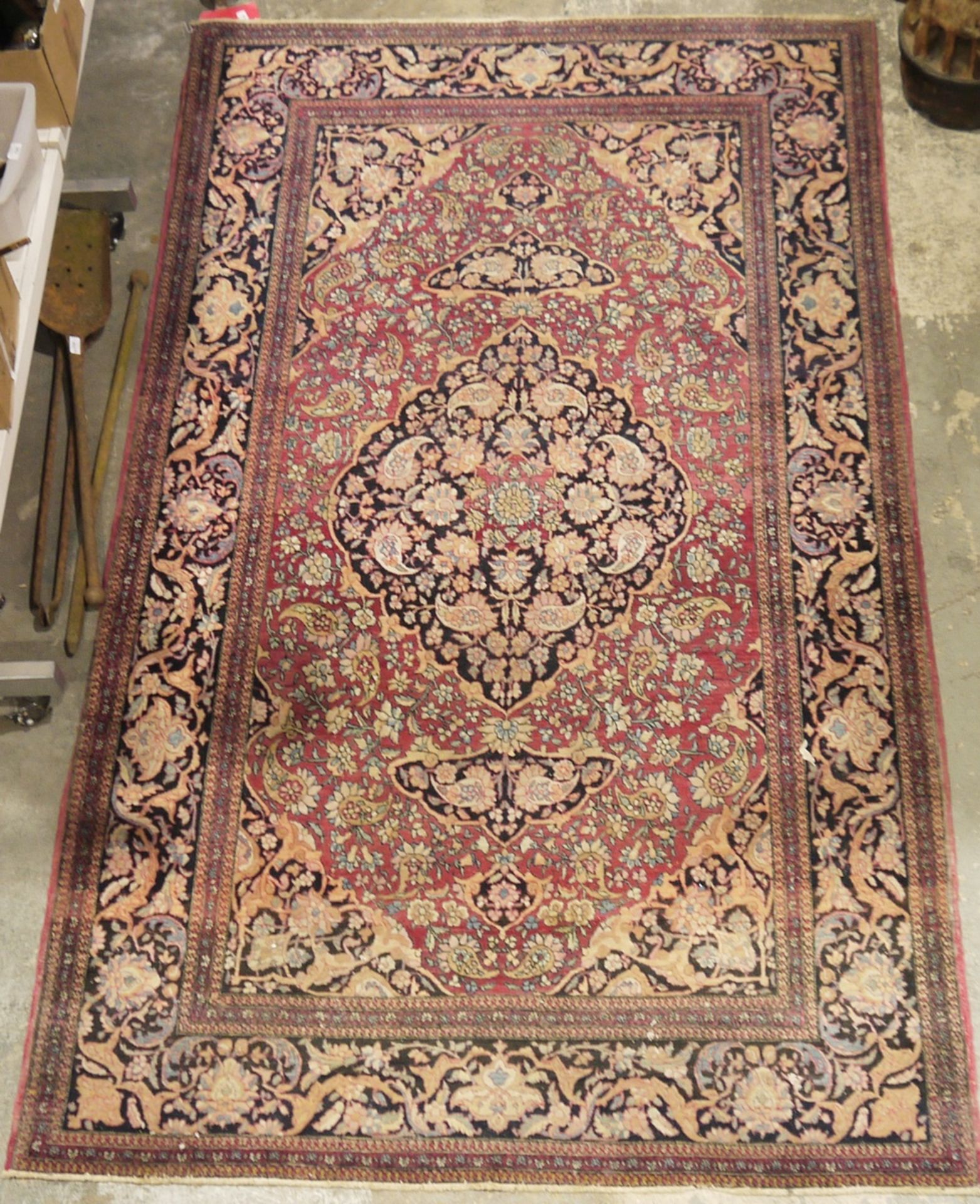 Eastern wool rug of Persian design, having black arabesque to the cherry red field with allover