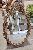 20th century gilt framed wall mirror of oval form, carved grape and vine frame, 90cm high x 60cm