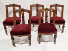 Set of five carved oak dining chairs with burgundy upholstered seats, on turned and carved front