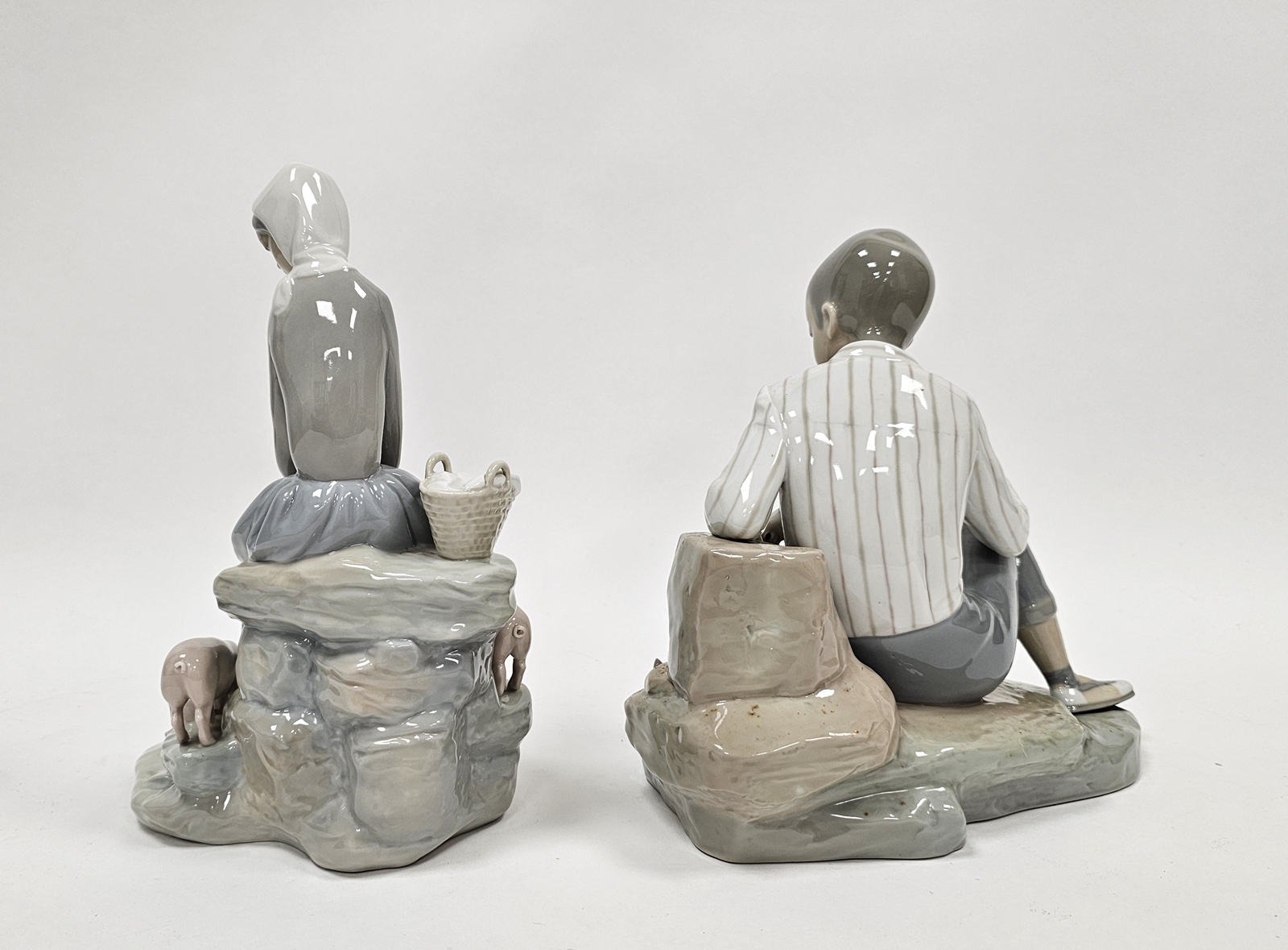 Lladro figures of a boy with dog and a girl with piglets, each modelled seated on rockwork, - Image 2 of 4