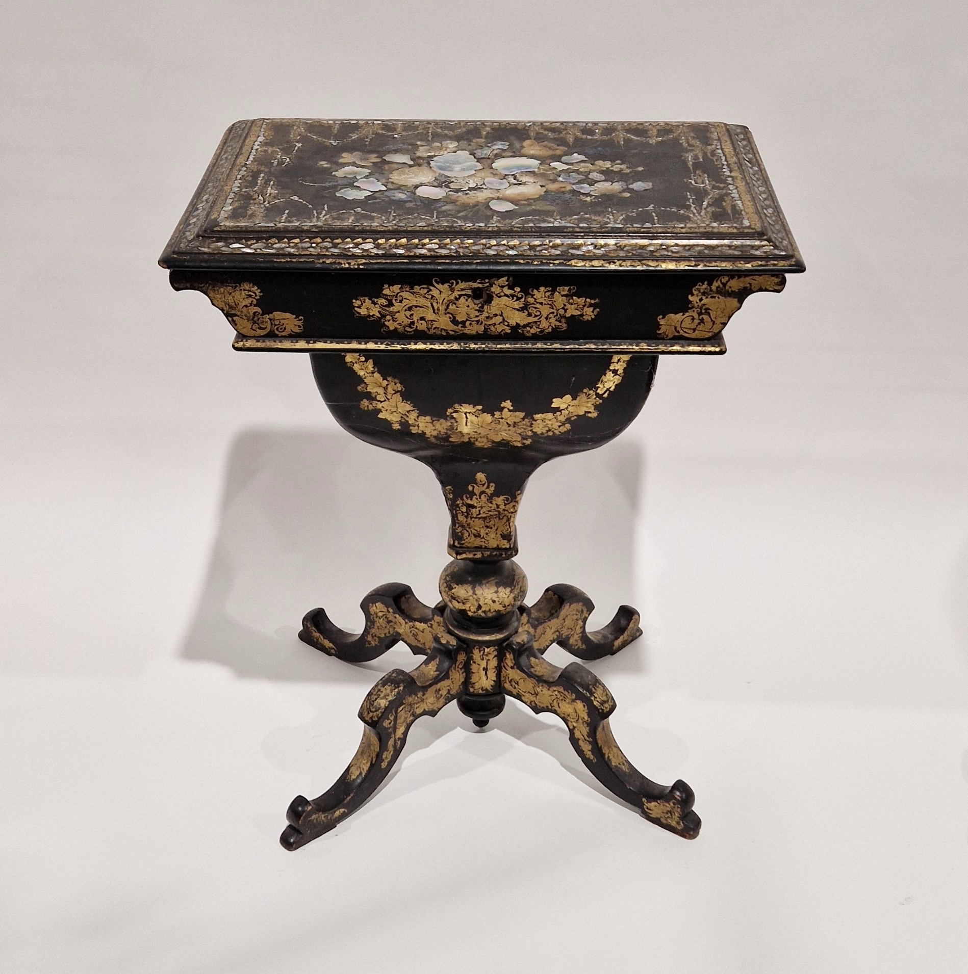 Victorian papiermache work table, the rectangular top inlaid with mother-of-pearl flowers and