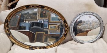 Gilt and ebonised wall mirror of oval form with bevelled edge, 76cm wide x 57cm high and a smaller